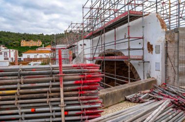 Silves, Portekiz, 11-21-2024 Eski Köprü Ponte Velha Roma Köprüsü koruma onarımından geçiyor. Ön planda yığılmış iskele boruları