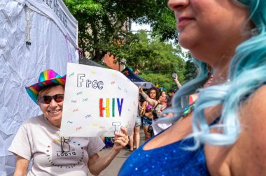 Philadelphia, PA USA, 06-02-2024 Havalı, Temple Health 'dan gökkuşağı şapkalı kadın elinde ücretsiz HIV testi için yapılmış el yazısı var.