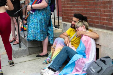 Philadelphia, PA, ABD, 06-02-2024 Central City 'deki Philly Onur Festivali' nde kalabalık şehir kaldırımı. Kaldırımda oturan bir çift..