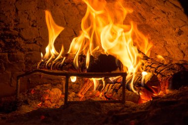 Kalorifer ocağında ateş yanıyor. Odunların alevler içindeki görüntüsünü kapat