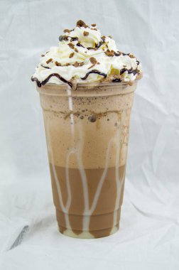 Plastik bardak çikolatalı milkshake. Beyaz arka planda krem şantili.