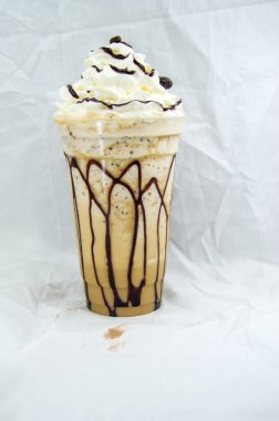 Plastik bardak çikolatalı milkshake. Beyaz arka planda krem şantili.