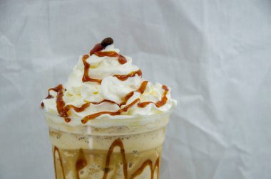 Plastik bardak çikolatalı milkshake. Beyaz arka planda krem şantili.