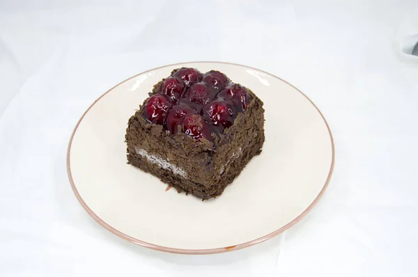 Beyaz arka planda lezzetli çikolata ve vişneli pasta.