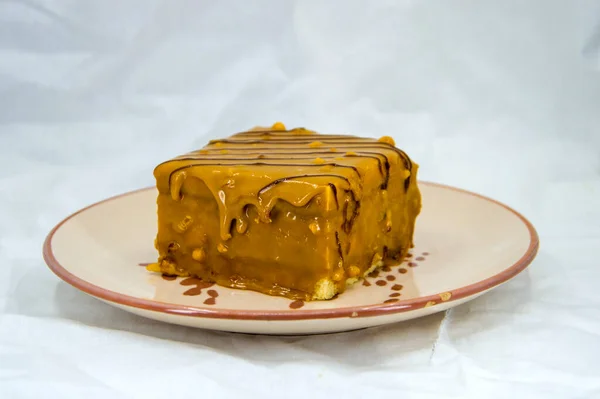 Beyaz arka planda karamel ve çikolatalı pasta.