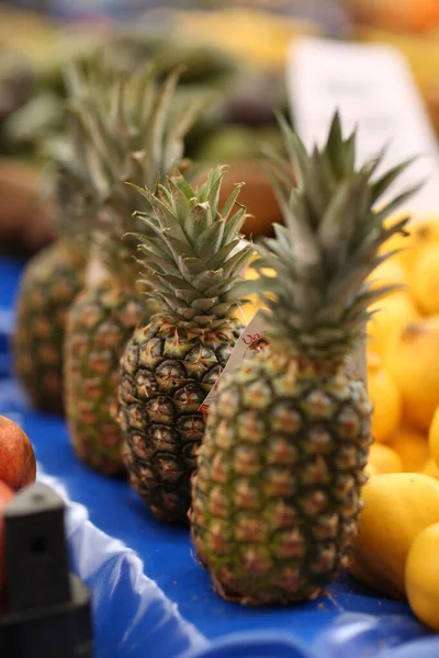 pineapples waiting to be sold on the market shelf