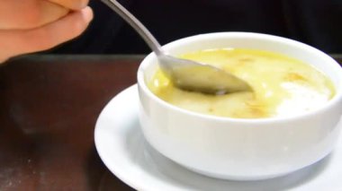 customer drinking the soup he ordered at the table