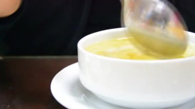 customer drinking the soup he ordered at the table
