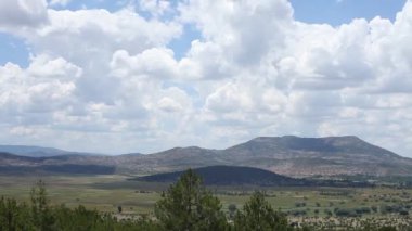 Zaman bulutu dağlar arasındaki yeşil tarlaları vurdu