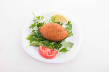 Türk yemeği bulguru ve kırmızı et kombinasyonuyla yapıldı, servis sırasında bol yağda kızartıldı ve sebzelerle servis edildi