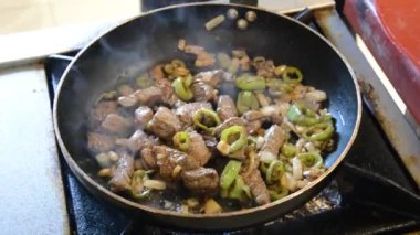 Kızarmış soğan, biber ve tavada et.