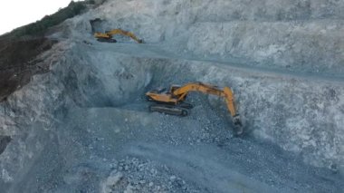 İnşaat alanında çalışan kamyon ve kazıcının hava görüntüleri.