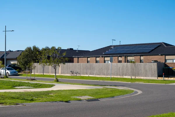 Background texture of a suburban street in an Australian neighbourhood with single storey residential house, family car parked on side of the asphalt road, grass nature stripe. Copy space