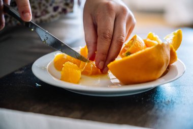 Biri tabakta portakal kesiyor. Yüksek kalite fotoğraf