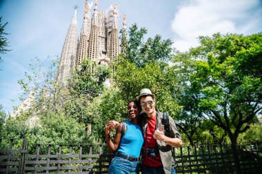 Barcelona 'daki Sagrada Familia kilisesinin önünde gülümseyen mutlu turist portresi