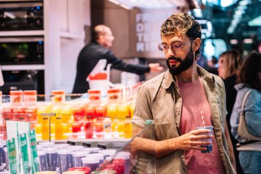 Müşteri meyve suyu tezgahından taze meyve suyu seçerek sağlıklı tercihlere ve canlı tatlara odaklanıyor.