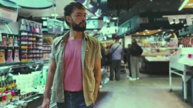 Tarz sahibi bir adam Boqueria, Barcelona 'da dolanıp taze ürünleri keşfediyor.