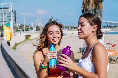 Barcelona 'da Barceloneta Sahili' nde antrenman yaptıktan sonra ferahlatıcı ve susuz kalan iki kız.