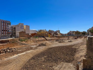 Büyük bir inşaat sahasında çalışan buldozerler ve kazıcılar, 30 Mart 2025 tarihinde İspanya 'nın Valencia kentindeki Paiporta şehrinde açık mavi bir gökyüzü altında kentsel manzarayı yeniden şekillendirdiler..