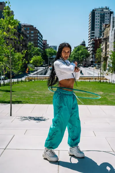 Havalı dansçı, hula hoop 'taki yeteneklerini şehir parkında gösteriyor.