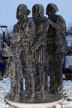 Columbus Ohio January 5, 2025 Modern sculpture depicting a family group in an urban setting during winter. clipart