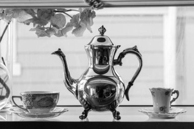 Long Beach CA 15 Ağustos 2020 Gümüş çaydanlık ve porselen bardak bir Bay Window 'da duruyor.