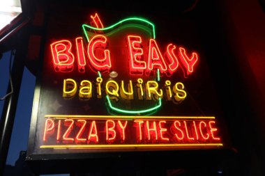 New Orleans Los Angeles 14 Şubat 2025 'te New Orleans Bourbon Caddesi' ndeki Mardi Gras kutlamaları sırasında Big Easy daiquiris ve pizza dilimlerinin sergilendiği neon levha..