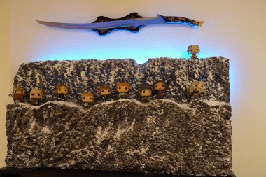 Alcala de Henares, Spain. January 7, 2023. Diorama of the company of the ring plus gollum from the movie the lord of the rings on the side of a mountain and an elven sword on top