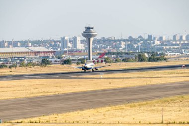 White, blue and yellow Ryanair airline plane with Irish flag and registration EI-EF with the landing gear down approaching to land at Madrid Barajas.
