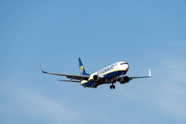 Boeing 737-8AS B738 white, blue and yellow Ryanair airline with registration EI-EBA, Irish flag and the landing gear lowered for landing at Barajas.