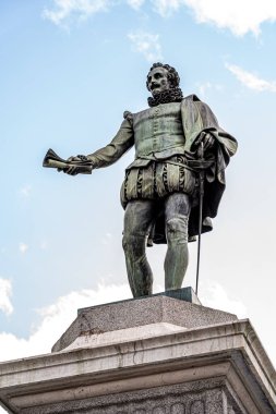 Madrid, İspanya. 15 Mayıs 2023. Miguel de Cervantes 'in Plaza de las Cortes' teki heykeli Neptün 'e ve Milletvekilleri Meclisi' ne bakıyor..