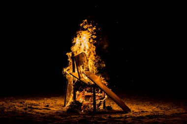 Gece Alicante 'deki San Juan şenlik ateşi festivalinde daha fazla odunla yanan sandalye..