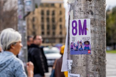 23 Mart 2023. Madrid, İspanya. Uluslararası Kadınlar Günü lehine 8M civarında çıkartma stili afişi Madrid 'deki kalabalık bir yaya geçidinin yanındaki bir sokak lambasına yapıştırılmış..