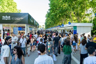 Madrid, İspanya. 16 Haziran 2024. 2024 'ün son gününde El Retiro parkındaki Madrid Kitap Fuarı' nın tribünlerinde toplanan kalabalık....