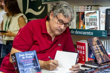 Madrid, İspanya. 16 Haziran 2024. Yazar Juan Manuel de Prada, El Retiro Park 'taki Madrid kitap fuarındaki La Casa del Libro standında kitap imzalıyor..