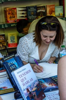 Madrid, İspanya. 16 Haziran 2024. Yazar Barbara Montes, La Casa del Libro 'nun 2024 sayısının son gününde El Retiro parkındaki Madrid kitap fuarında kitap imzalıyor..