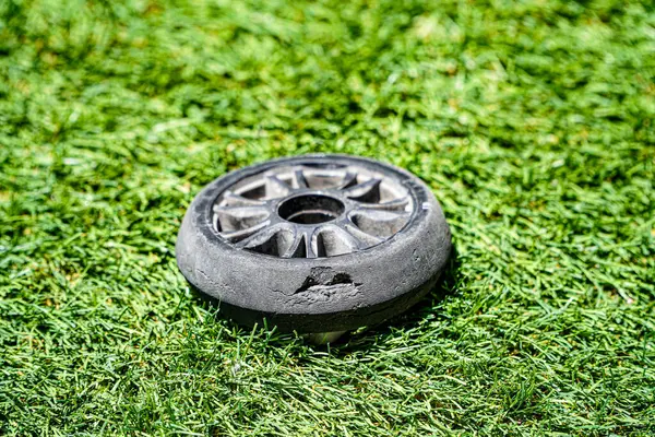 stock image Wheel of some skates, black color and original size 110mm, in very worn condition with a bite due to wear and tear and use on an artificial turf surface. 