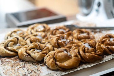 Çikolatayla dolu bükülmüş hamur işi, parlak bir kaplama ve kaba şekerle kaplı. Fırın tepsisinde taze pişmiş tatlı..