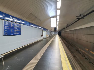 Madrid, İspanya. 3 Şubat 2024. İspanya 'nın Madrid kentindeki Tribunal metro istasyonunun 2 numaralı platformu tamamen boş. Reklam ekranları, istasyon tabelaları ve yolcuların oturacağı banklarla..