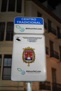 Alicante, İspanya. 2 Mayıs 2025. Alicantes geleneksel merkezinde, şehir amblemi ve AlicanTeCuida girişiminin yer aldığı düşük emisyon bölgesini gösteren dikey işaret.