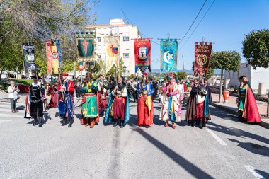 Onil, Alicante. 1 Mayıs 2025. Moors ve Hristiyanların Onil, Alicante 'deki geçit töreninin başlangıcında, yerel şenlikler sırasında renkli pankartlar taşıyan katılımcılar.