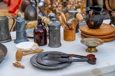 Eski mutfak aletleri, tahtadan, metal çatal bıçaklardan, sürahilerden ve plakalardan oluşan 1600 civarından, tarihi bir yeniden canlandırma düzeninde beyaz bir bez üzerine yerleştirilmiş..