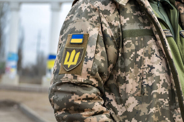 Украинский солдат в армии и флаге, герб с золотым трезубцем на военном фоне. Вооружённые силы Украины.
