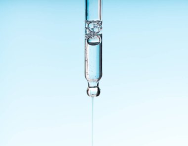 Pipette serumu, temiz sıvı niasinamide, hyaluronik ya da mavi beyaz izole arkaplanda Aha Bha asitleri. Tüylü kumaş parçası. Laboratuvar kozmetiği