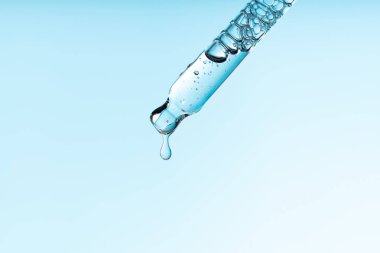 Pipette serumu, temiz sıvı niasinamide, hyaluronik ya da mavi beyaz izole arkaplanda Aha Bha asitleri. Tüylü kumaş parçası. Laboratuvar kozmetiği