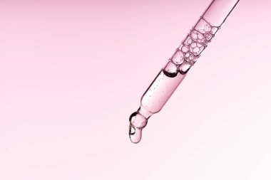 Pipette serumu, temiz sıvı niasinamide, hyaluronik ya da Aha Bha asitli pembe beyaz izole arka planda. Tüylü kumaş parçası. Laboratuvar kozmetiği