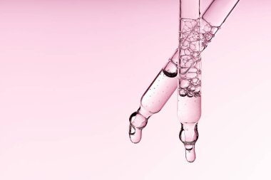 Pipet serumunu temiz sıvı niasinamide, hyaluronik ya da Aha Bha asitleriyle pembe beyaz izole arkaplanda bırakın. Tüylü kumaş parçası. Laboratuvar kozmetikleri