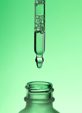 Pipette serum with clear liquid niacinamide, hyaluronic or Aha Bha acids on a green isolated background. Textured swatch skincare. Laboratory cosmetic clipart
