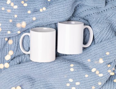 Beyaz boş kupa, tasarımın için fincan ve mavi süveter ve battaniye. Promosyon metni veya tanıtım içeriği için şablon boş