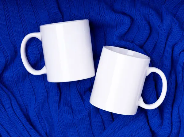 Mock up white empty mug, cup for your design and logo closeup blue sweater, blanket. Template blank for promotional text message or promotional content